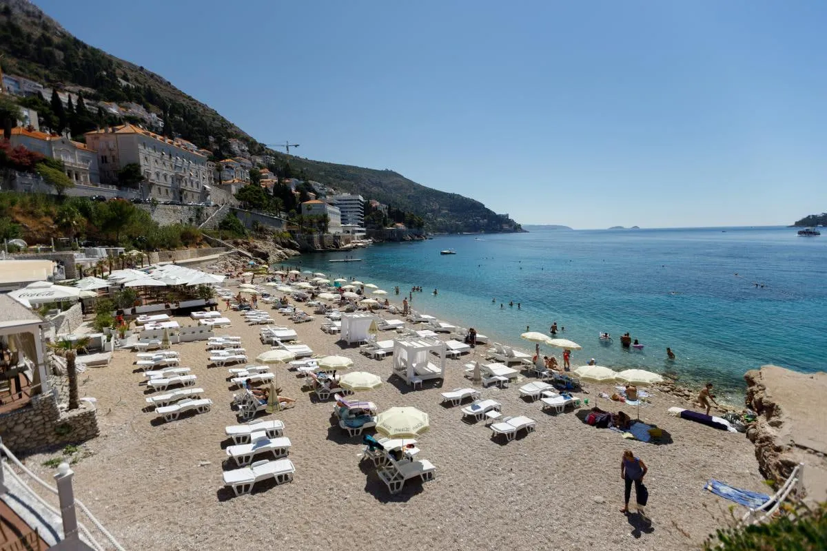 On Croatia's beaches, tourists stake out spots in the shade even before dawn