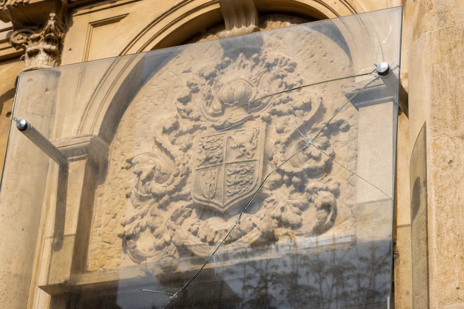 Protective cover of British coat of arms damaged on old courts building in Nicosia