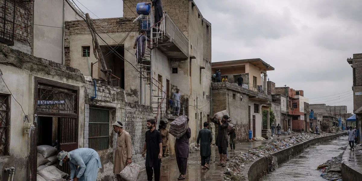 Women in Rawalpindi prepare for floods near Nullah Lai — Dawn