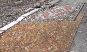 Фото: в Днепре жители одного из домов закрыли ямы на дорогах коврами